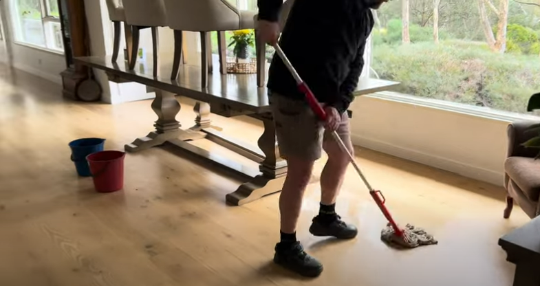 man mopping the floor with a cotton mop